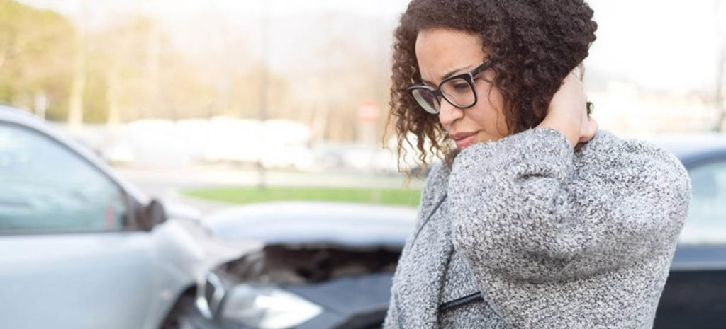 Woman in distress in front of her car that has been in a vehicle crash. Contact our truck accident attorneys in St. Louis today.