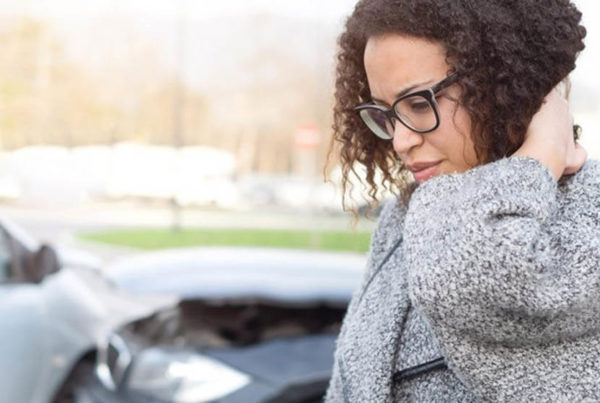 Woman in distress in front of her car that has been in a vehicle crash. Contact our truck accident attorneys in St. Louis today.